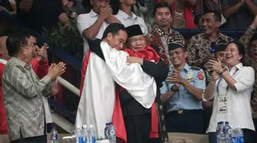 Presiden Joko Widodo atau Jokowi dan Ketua Umum Pengurus Besar Ikatan Pencak Silat Indonesia (IPSI) Prabowo Subianto memeluk atlet pencak silat Hanifan Yudani di Jakarta, Rabu (29/8). (ANTARA FOTO/Kumparan/INASGOC/Aditia Noviansyah/pras/18)