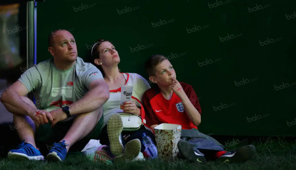 Suporter Inggris yang datang sekeluarga ini tampak kecewa dengan penampilan Wayne Rooney dan kawan-kawan yang gagal menang lawan Islandia. (Bola.com/Vitalis Yogi Trisna)