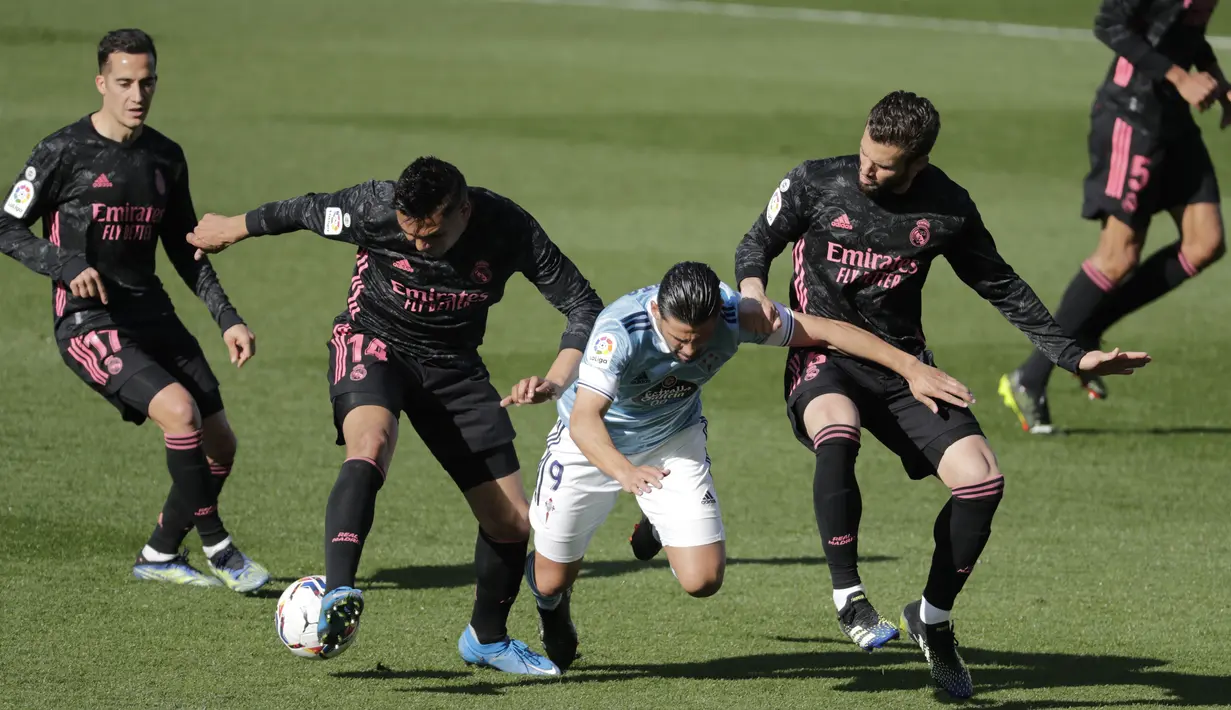 Penyerang Celta Vigo, Nolito berada di antara pemain Real Madrid, Casemiro dan Nacho  pada lanjutan Liga Spanyol 2020/2021 di Balaidos, Sabtu (20/3/2021). Karim Benzema jadi bintang saat Real Madrid melibas Celta Vigo 3-1. (AP Photo/Lalo R.Villar)
