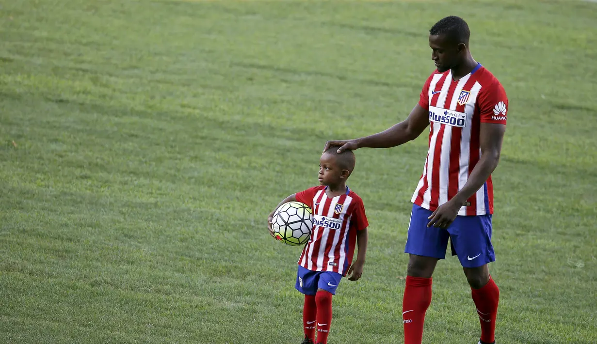 Jackson Martinez menggandeng anaknya Josue saat diperkenalkan sebagai pemain baru Atletico Madrid di Stadion Vicente Calderon, Madrid, Minggu (26/7/2015).(Reuters/Susana Vera)