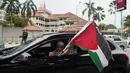 Warga Muslim membawa bendera Palestina saat konvoi protes menentang serangan Israel di Gaza di luar Kedutaan Besar Amerika Serikat di Kuala Lumpur, Malaysia, Jumat (21/5/2021).  (AP Photo / Vincent Thian)