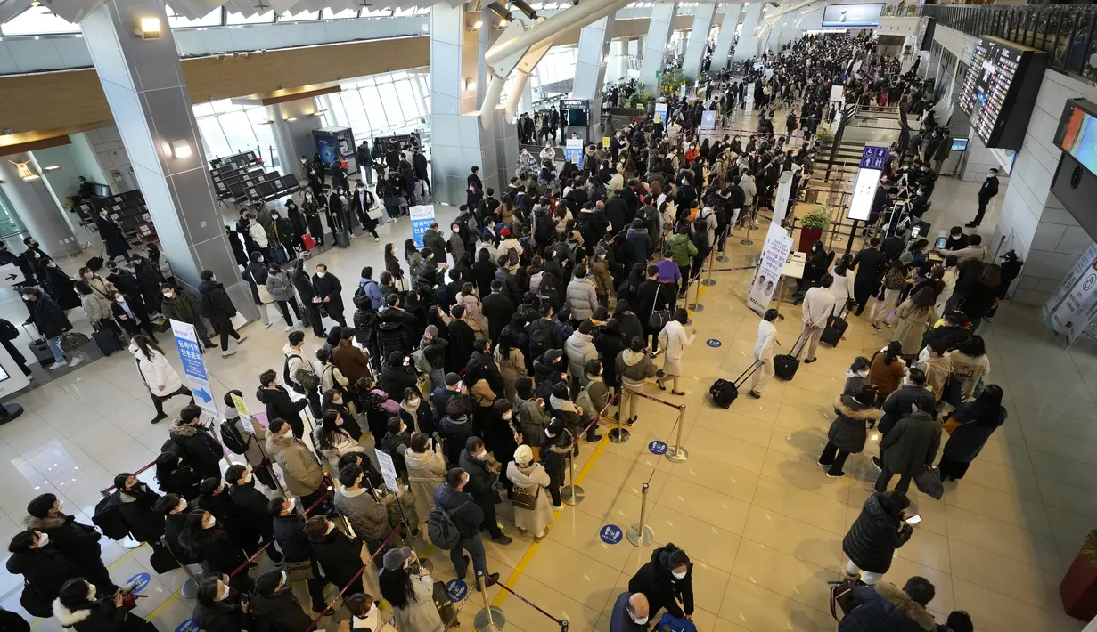 Antrean penumpang yang mengenakan masker untuk naik  pesawat menjelang liburan Tahun Baru Imlek, di terminal penerbangan domestik bandara Gimpo di Seoul, Korea Selatan, Sabtu (29/1/2022). Libur Imlek di Korsel dimulai mulai 30 Januari hingga 2 Februari mendatang. (AP Photo/Ahn Young-joon)