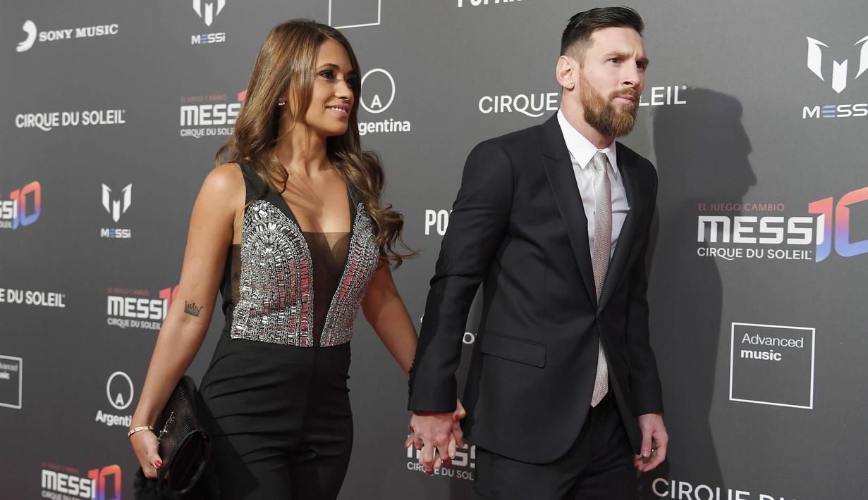 Bintang Barcelona, Lionel Messi dan istrinya Antonella Roccuzzo, bergandengan tangan saat menghadiri sesi pemotretan acara terbaru Cirque du Soleil "Messi 10" di Barcelona, (31/1/2019). (AFP/Lluis Gene)