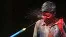 Seorang anak India terkena semprotan air berwarna selama festival Holi di Chennai (2/3). Holi, festival musim semi hindu di India yang diadakan 2 Maret tahun ini pada akhir musim dingin pada bulan purnama pertama kalender lunar. (AFP Photo/Arun Sankar)