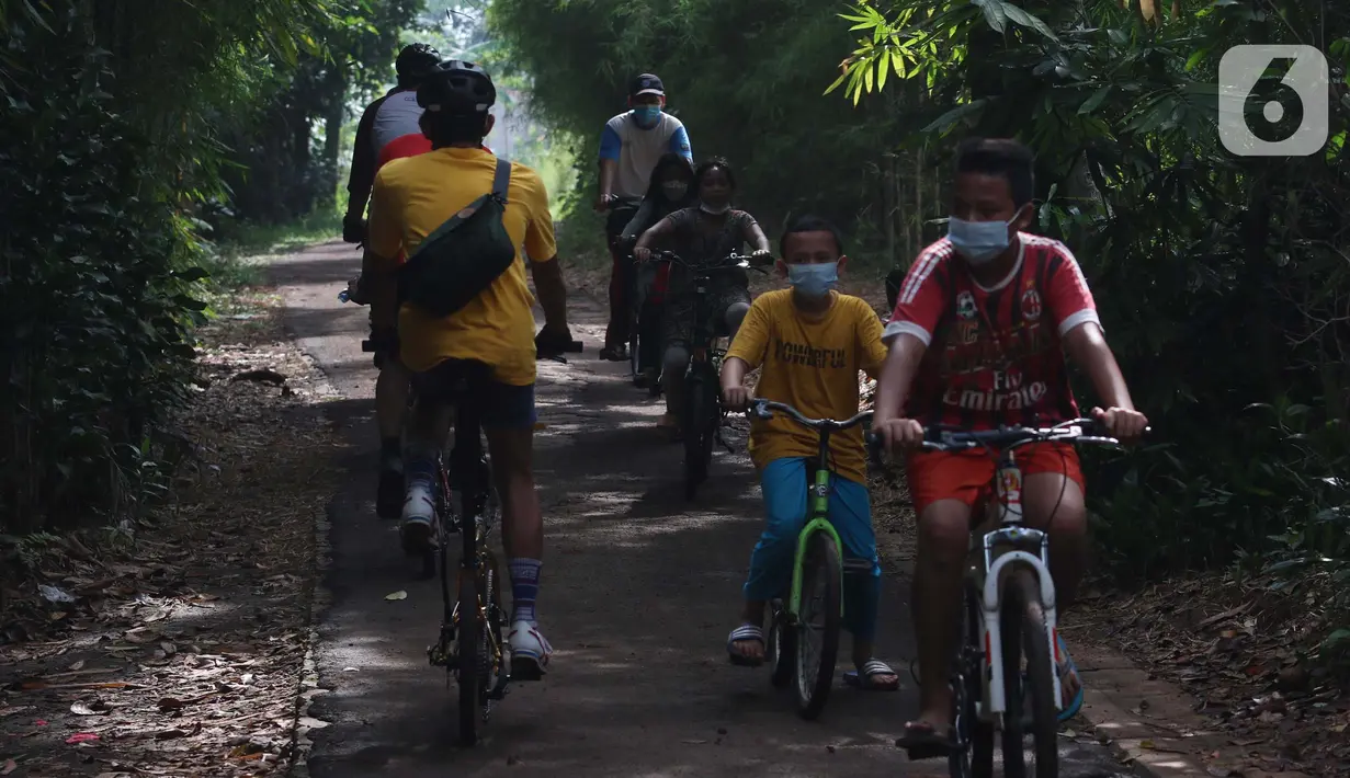 Anak-anak bersepeda di perkampungan di Parigi, Tangerang Selatan, Minggu (24/10/2021). Beresepeda memasukin perkampungan dengan nuansa alam banyak di manfaatkan masyarakat untuk mencari suasana yang asri dan jauh dari keramaian kota. (Liputan6.com/Angga Yuniar)