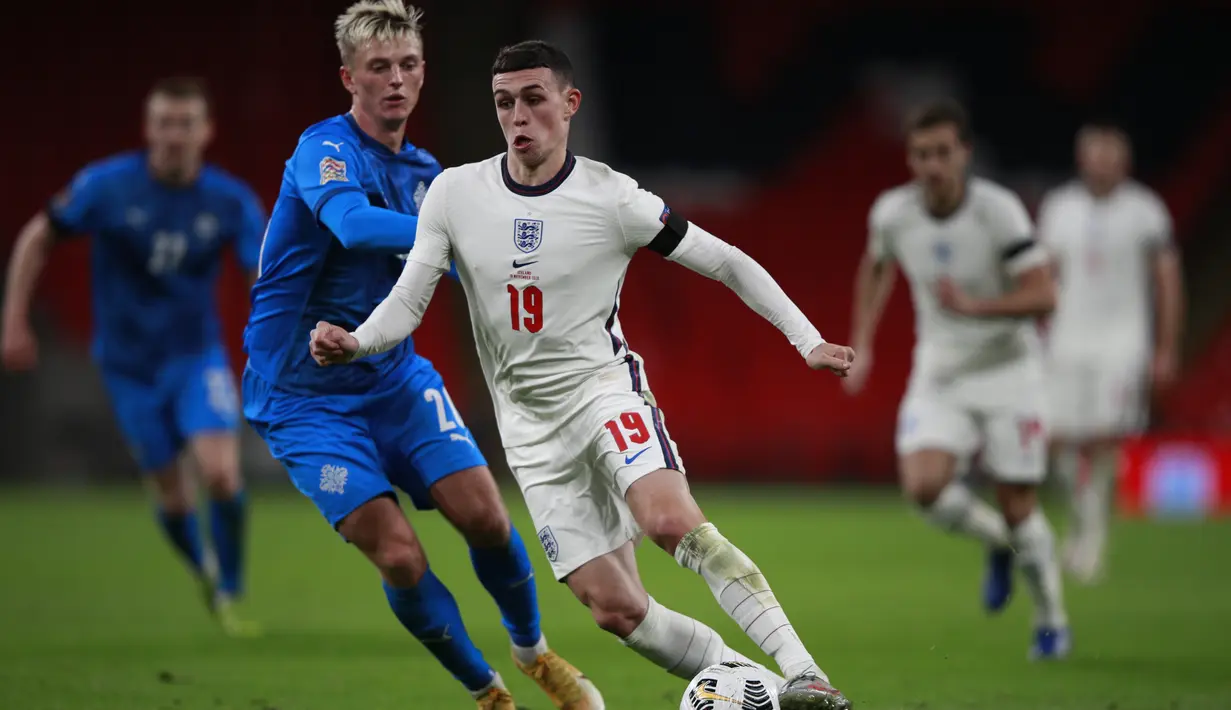 Gelandang Inggris, Phil Foden menggiring bola dari kawalan pemain Islandia, Albert Gudmundsson pada pertandingan UEFA Nations League di stadion Wembley, London (18/11/2020). Meski menang, Inggris tetap gagal lolos ke putaran final atau babak semifinal UEFA Nations League. (AP Photo/Ian Walton, Pool)