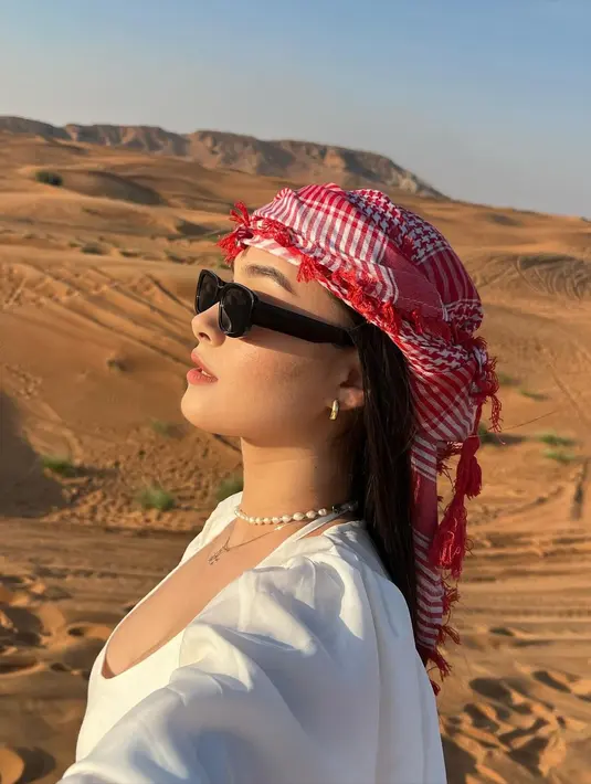 Ia padukan cropped top bertali dengan loose pants putih dan puffy outer. [@caitlinhalderman]