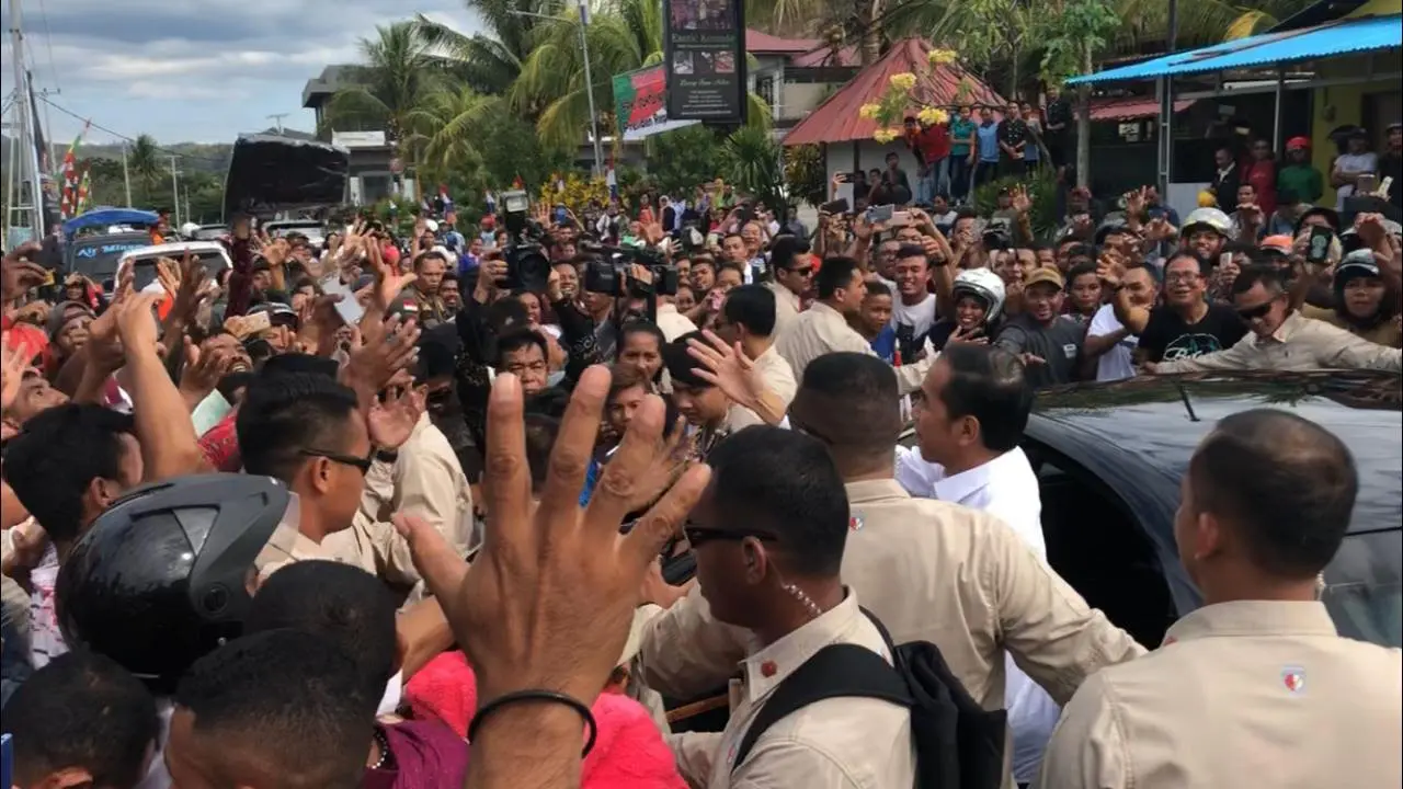 Presiden Joko Widodo atau Jokowi membagi-bagikan kaus kepada warga di Labuan Bajo, NTT.