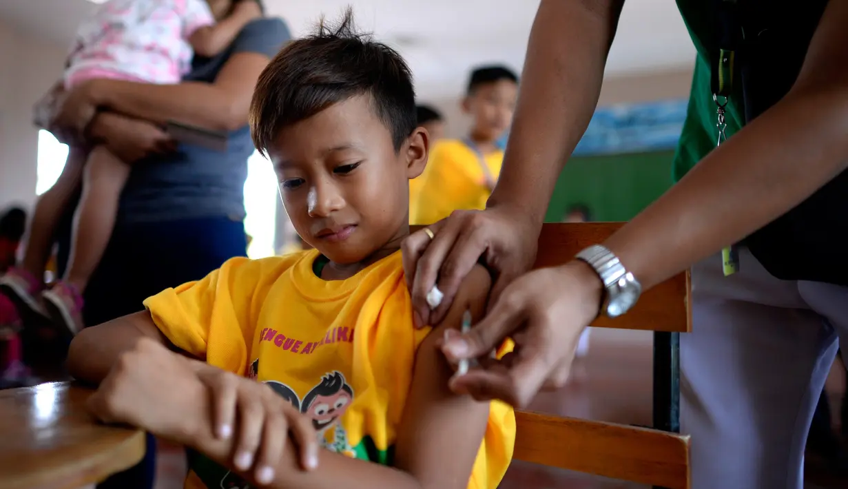 Perawat menyuntikkan vaksin anti-dengue di Sekolah Dasar Parang di Marikina, sebelah barat Manila, Senin (4/4). Filipina telah menyuntikkan vaksin pertama di dunia untuk penyakit Demam Berdarah Dengue (DBD) itu kepada 1 juta pelajar. (NOEL CELIS/AFP)