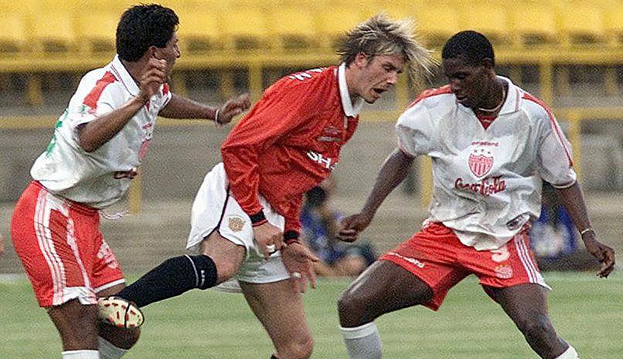 Gelandang Manchester United, David Beckham (tengah) dikurung dua pemain Necaxa dalam laga Grup B Piala Dunia Antar-klub 2000 di Maracana Stadium, Sao Paulo (6/1/2000). Manchester United yang berstatus juara Liga Champions 1998/1999 gagal lolos ke babak empat besar edisi perdana Piala Dunia Antar-klub pada 2000 karena hanya menempati posisi ketiga Grup B yang dihuni Vasco Da Gama, Necaxa dan South Melbourne. Corinthians akhirnya menjadi juara setelah menang adu penalti atas Vasco Da Gama. (AFP/Vanderlei Almeida)