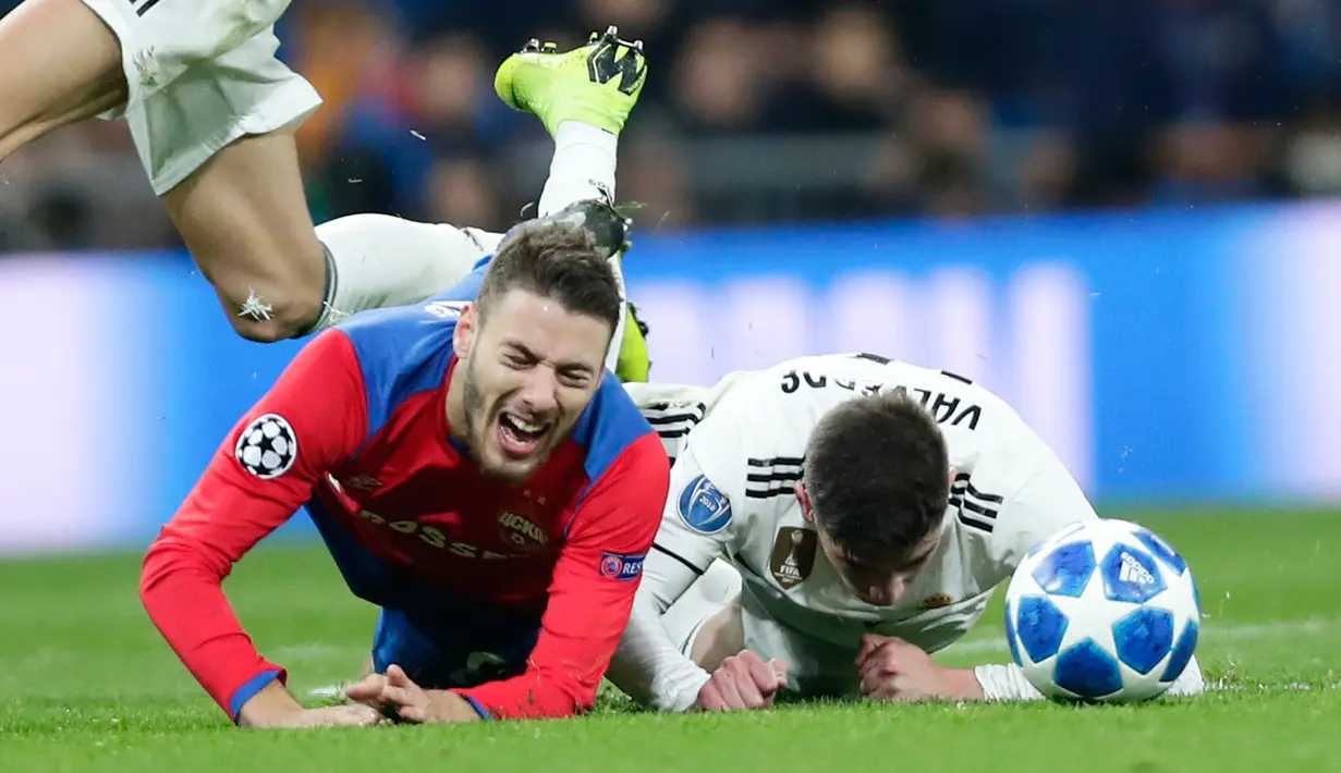 Bek Real Madrid, Raphael Varane dan gelandang CSKA Moscow, Nikola Vlasic terjatuh saat berebut bola pada laga terakhir Grup G Liga Champions di Santiago Bernabeu, Rabu (12/12). Real Madrid takluk dengan skor 0-3 dari CSKA Moscow. (AP/ Manu Fernandez)