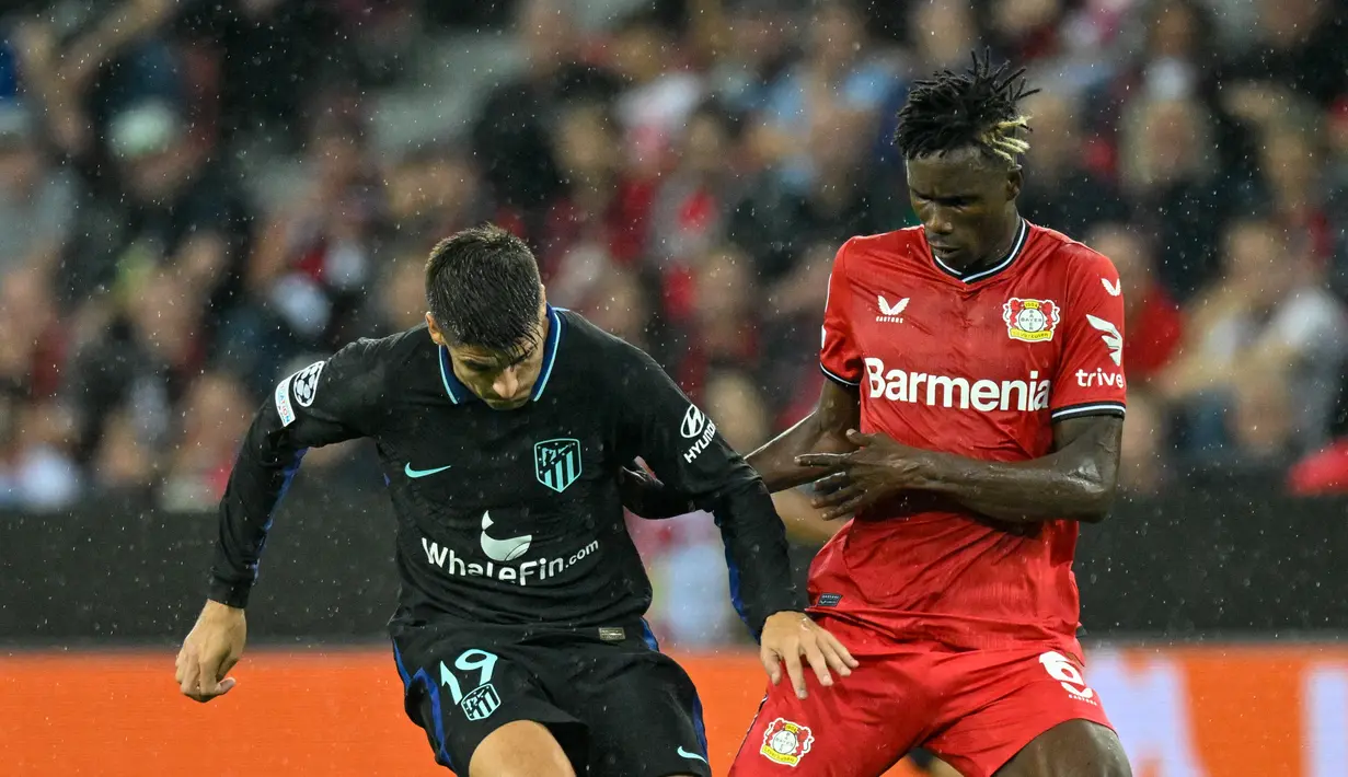 <p>Bek Bayer Leverkusen Odilon Kossounou berebut bola dengan gelandang Atletico Madrid Alvaro Morata dalam matchday kedua Grup B Liga Champions di BayArena, Rabu (14/9/2022) dini hari WIB. Bertandang ke markas Bayer Leverkusen, Atletico Madrid tumbang dengan skor 0-2. (Photo by Sascha Schuermann / AFP)</p>