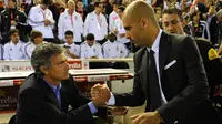 Pelatih asal Portugal Jose Mourinho (kiri) berjabat tangan dengan pelatih Barcelona Josep Guardiola sebelum pertandingan final Piala Spanyol Real Madrid melawan Barcelona di Stadion Mestalla di Valencia pada 20 April 2011. (AFP PHOTO/Lluis GENE)