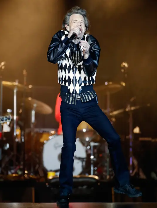 Penampilan Mick Jagger saat konser Rolling Stones dalam tur 'No Filter' di Soldier Field, Chicago, Amerika Serikat, Jumat (21/6/2019). Jagger sebagai pentolan Rolling Stones tampil dengan jeans hitam dan jaket hitam putih. (Kamil Krzaczynski/AFP)
