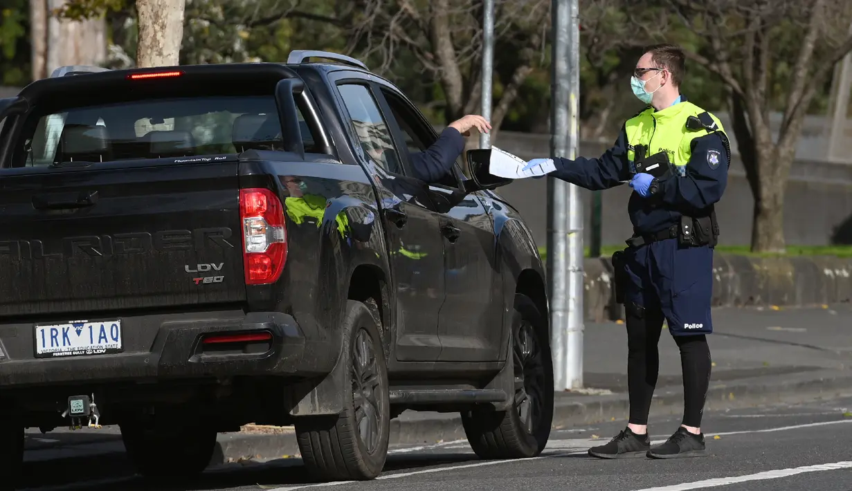 Petugas polisi menghentikan mobil untuk pemeriksaan izin selama tahap empat penguncian kota yang ketat karena wabah COVID-19 di Melbourne (11/8/2020). Negara bagian Victoria melaporkan 19 kematian akibat virus corona pada 11 Agustus. (AFP/William West)