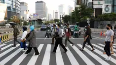 Pejalan kaki melintasi lajur penyebrangan Jalan Jenderal Sudirman, Jakarta, Rabu (23//9/2020). Menteri Keuangan Sri Mulyani Indrawati memastikan ekonomi nasional resesi pada kuartal III-2020, perekonomian Indonesia akan mengalami kontraksi hingga minus 2,9 persen. (Liputan6.com/Helmi Fithriansyah)