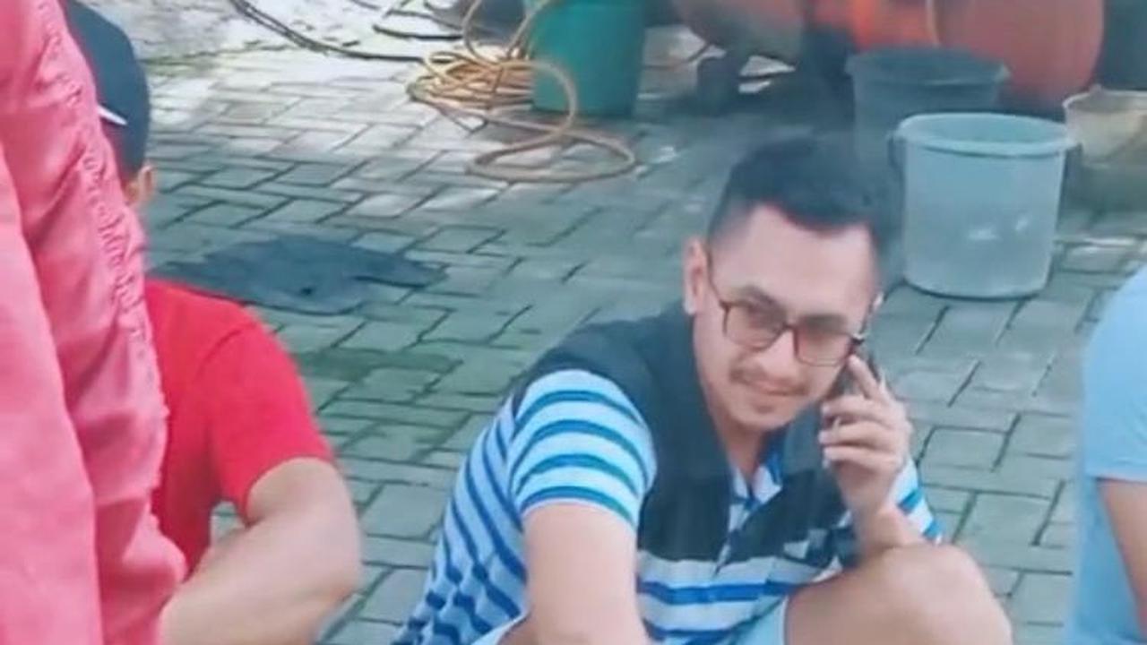 Selanjutnya, tampak seorang pria berbaju garis sedang duduk dengan ekspresi lemas sambil sibuk menelepon.&nbsp;