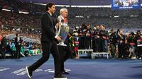 Mantan pemain Liverpool, Ian Rush (kanan), dan mantan pemain Real Madrid, Raul (kiri), membawa trofi di lapangan sebelum pertandingan final Liga Champions UEFA antara Liverpool dan Real Madrid di Stade de France di Saint-Denis, utara Paris, pada 28 Mei 2022. (FRANCK FIFE/AFP)
