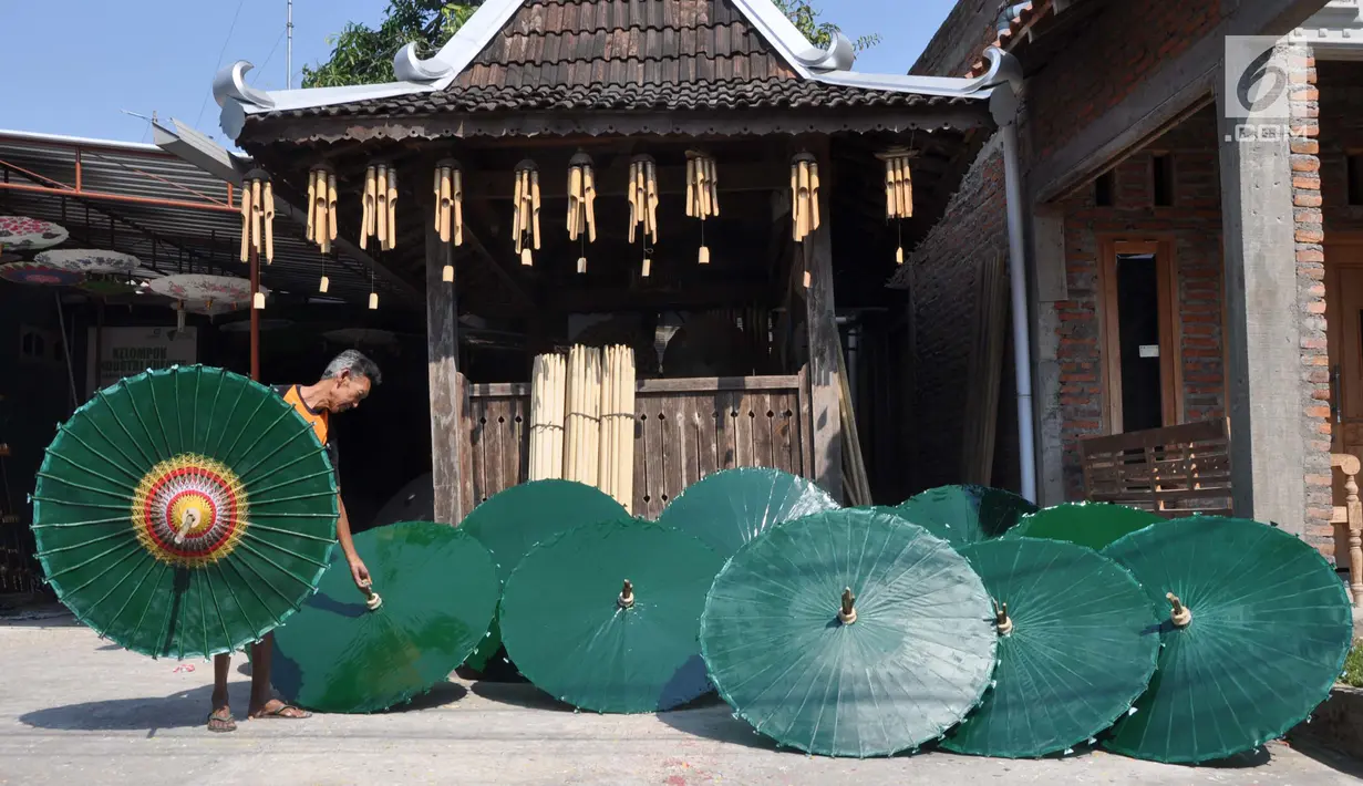 Perajin menjemur payung hias tradisional di Desa Tanjung, Kecamatan Juwiring, Klaten, Kamis (11/10). Harga per unit payung hias ini berkisar antara 50.000 hingga 3,5 juta rupiah tergantung dari ukuran. (Liputan6.com/Gholib)
