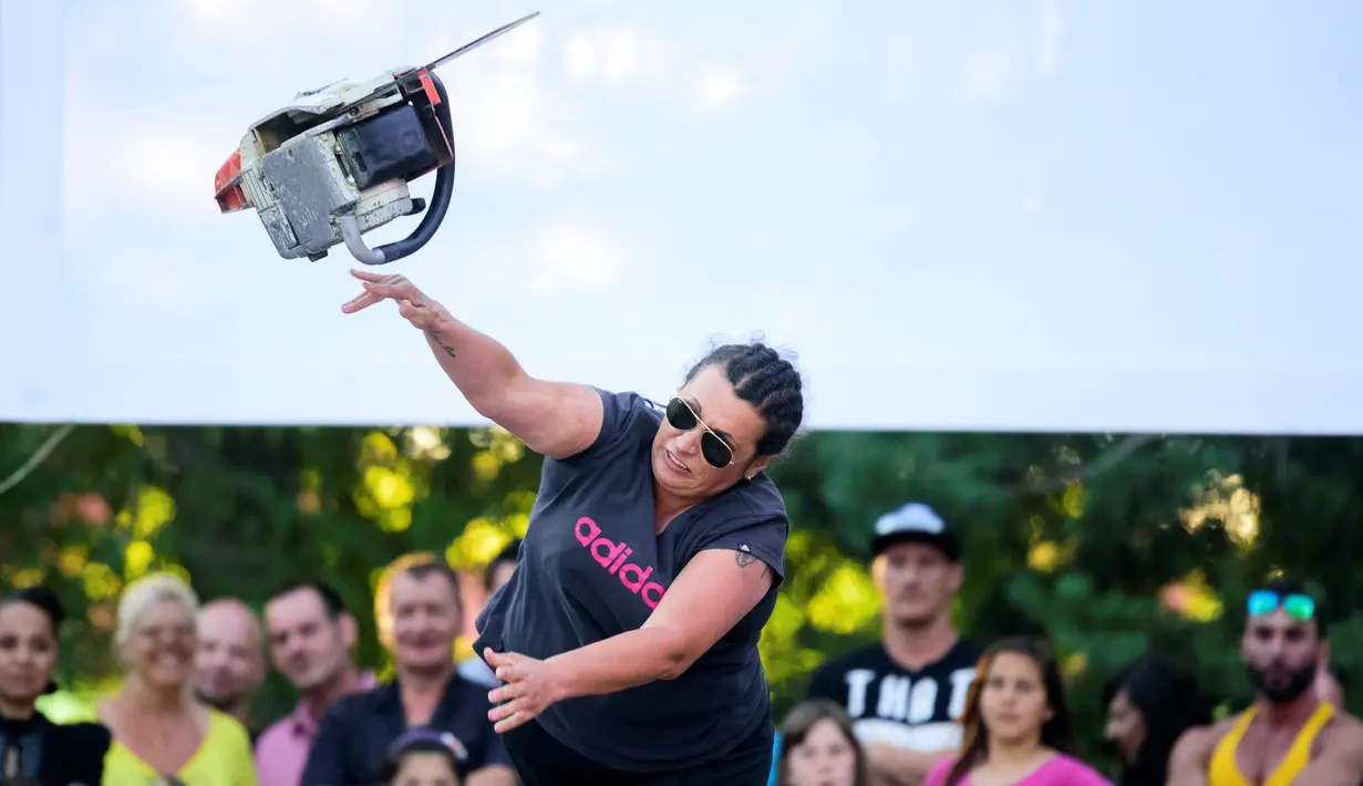 Seorang wanita melempar gergaji mesin saat mengikuti kompetisi dalam Kejuaraan Lempar Chainsaw ke-4 di Kocevje, Slovenia (1/7). (AFP Photo/Jure Makovec)