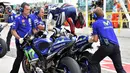 Pebalap Yamaha, Jorge Lorenzo, melompat ke motor pengganti setelah hujan turun saat balapan MotoGP San Marino di Sirkuit Misano, Minggu (13/9/2015). (AFP Photo/Vincenzo Pinto)