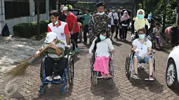 Peserta dan para penyandang disabilitas saat mengikuti kegiatan Hari Sampah Nasional di Jakarta, Minggu (13/3). Kegiatan yang disebut 'rampok sampah' ini membangkitkan kesadaran masyarakat terhadap kebersihan lingkungan. (Liputan6.com/ Immanuel Antonius)