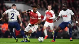 Striker Arsenal, Alex Iwobi, berusaha melewati bek Tottenham, Kieran Trippier, pada laga perempat final Piala Liga di Stadion Emirates, London, Rabu (19/12). Arsenal kalah 0-2 dari Tottenham. (AFP/Ben Stansall)