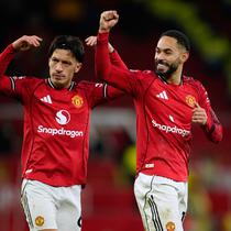 Lisandro Martinez (kiri) dan rekan setimnya, Matheus Cunha, memberikan apresiasi kepada suporter MU selepas duel melawan Newcastle United dalam lanjutan Liga Inggris 2025/2026 di Old Trafford, Sabtu (27/12/2025) dini hari WIB. (AP Photo/Dave Thompson)