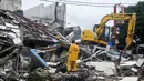 Alat berat membongkar reruntuhan bangunan PHD untuk mempermudah petugas Kepolisian melakukan proses olah TKP, Kota Bekasi, Minggu (23/10). Polisi akan melakukan olah TKP untuk memastikan penyebab ledakan tersebut. (Liputan6.com/Yoppy Renato)