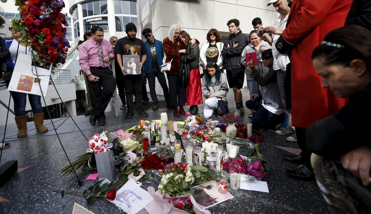 Penggemar berkumpul di dekat bintang atas nama penyanyi legendaris David Bowie di Hollywood Walk of Fame di Los Angeles, Senin (11/1). Bowie meninggal di usia 69 tahun dan baru saja merilis album ke-25 nya yaitu "Blackstar". (REUTERS/ Mario Anzuoni)