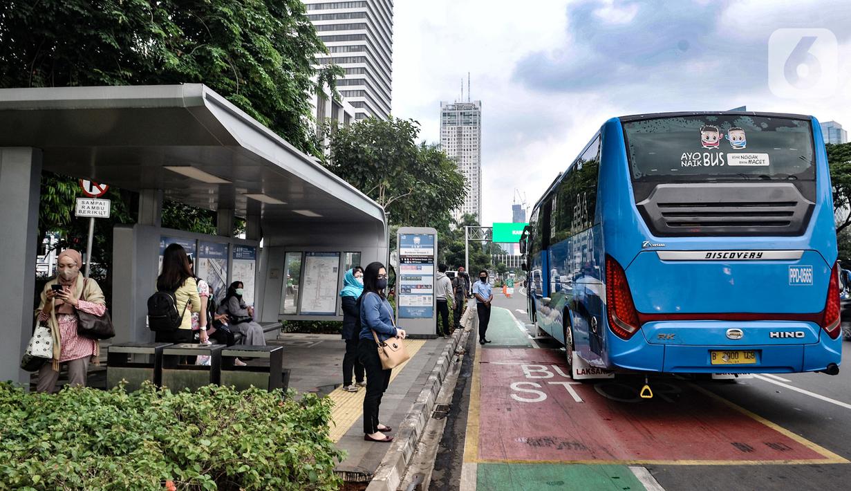 Sejumlah pekerja menunggu bus Transjakarta di Halte Dukuh Atas, Jakarta, Senin (14/9/2020). Selama PSBB, Pemprov DKI Jakarta mewajibkan perusahaan nonesensial untuk membatasi 25 persen dari total pekerja yang bekerja di kantor guna memutus penyebaran Covid-19. (merdeka.com/Iqbal S. Nugroho)