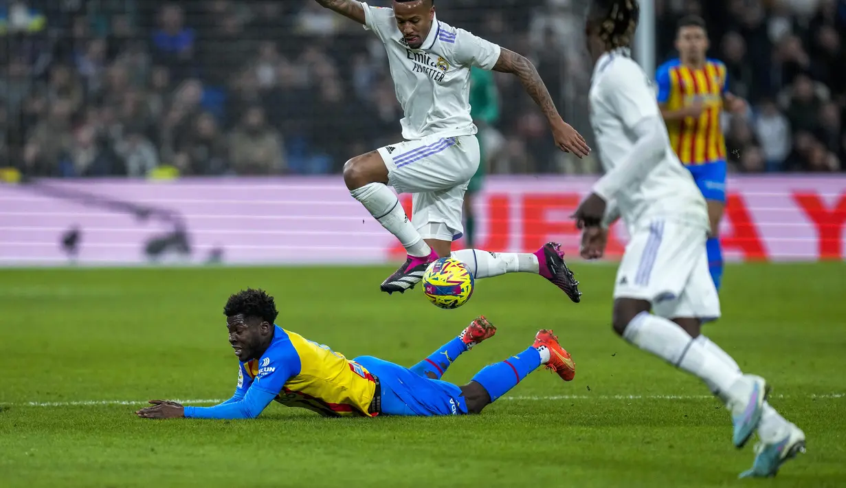 Bek Real Madrid, Eder Militao berusaha melewati pemain Valencia, Yunus Musah selama pertandingan La Liga Spanyol di stadion Santiago Bernabeu di Madrid, Jumat (3/2/2023). Hasil ini membuat Madrid bertahan di posisi dua klasemen Liga Spanyol dengan kini mengoleksi 45 poin, lima poin di belakang Barcelona. (AP/Bernat Armangue)