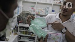 Warga saat membeli masker di Pasar Pramuka, Jakarta, Senin (2/3/2020). Pemerintah resmi mengumumkan dua pasein ibu (64) dan anak (31) terinfeksi wabah virus corona COVID-19 setelah berinteraksi dengan Warga Negara Jepang yang berkunjung ke Indonesia. (Liputan6.com/Faizal Fanani)