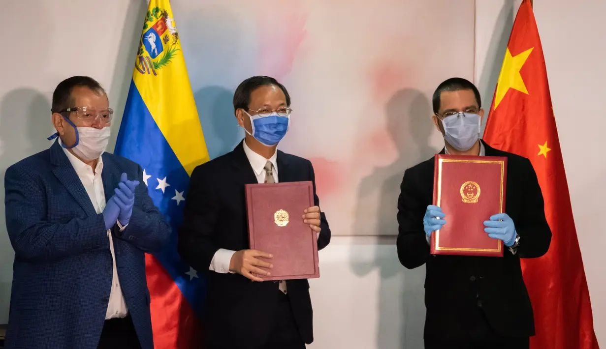Menteri Luar Negeri Venezuela Jorge Arreaza (kanan) dan Duta Besar China untuk Venezuela Li Baorong (tengah) berfoto bersama dalam upacara penyerahan suplai medis dari China di Caracas, Venezuela (30/3/2020). (Xinhua/Marcos Salgado)