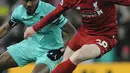 Bek Liverpool, Andrew Robertson menggiring bola dari kejaran pemain Arsenal, Ainsley Maitland-Niles pada lanjutan Liga Inggris di Anfield Stadium (29/12). Kemenangan ini, membuat Liverpool  kokok di puncak klasemen dengan poin 54. (AP Photo/Rui Vieira)