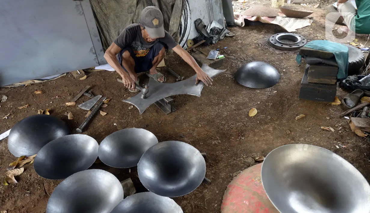 Perajin menyelesaikan pembuatan wajan yang terbuat dari pelat besi di Desa Cibadak, Tanah Sareal, Kabupaten Bogor, Jawa Barat, Rabu (5/8/2020). Pemerintah akan membantu usaha mikro, kecil, dan menengah (UMKM) dalam melewati masa pandemi COVID-19. (merdeka.com/Dwi Narwoko)