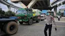 Polisi Lalu Lintas dan Dinas Perhubungan Daerah Khusus Jakarta melakukan pengaturan keluar masuk kendaraan truk kontainer di area Perempatan Pos IX Pelabuhan Tanjung Priok, Jakarta Utara, Jumat (18/4/2025). (Liputan6.com/Angga Yuniar)