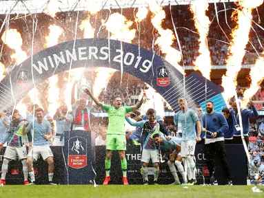 Pemain Manchester City Vincent Kompany (tengah) mengangkat trofi Piala FA 2018/2019 bersama rekan-rekannya di Stadion Wembley, London, Inggris, Sabtu (18/5/2019). The Citizens menjuarai Piala FA 2018/2019 usai mengalahkan Watford dengan skor 6-0. (Reuters/John Sibley)