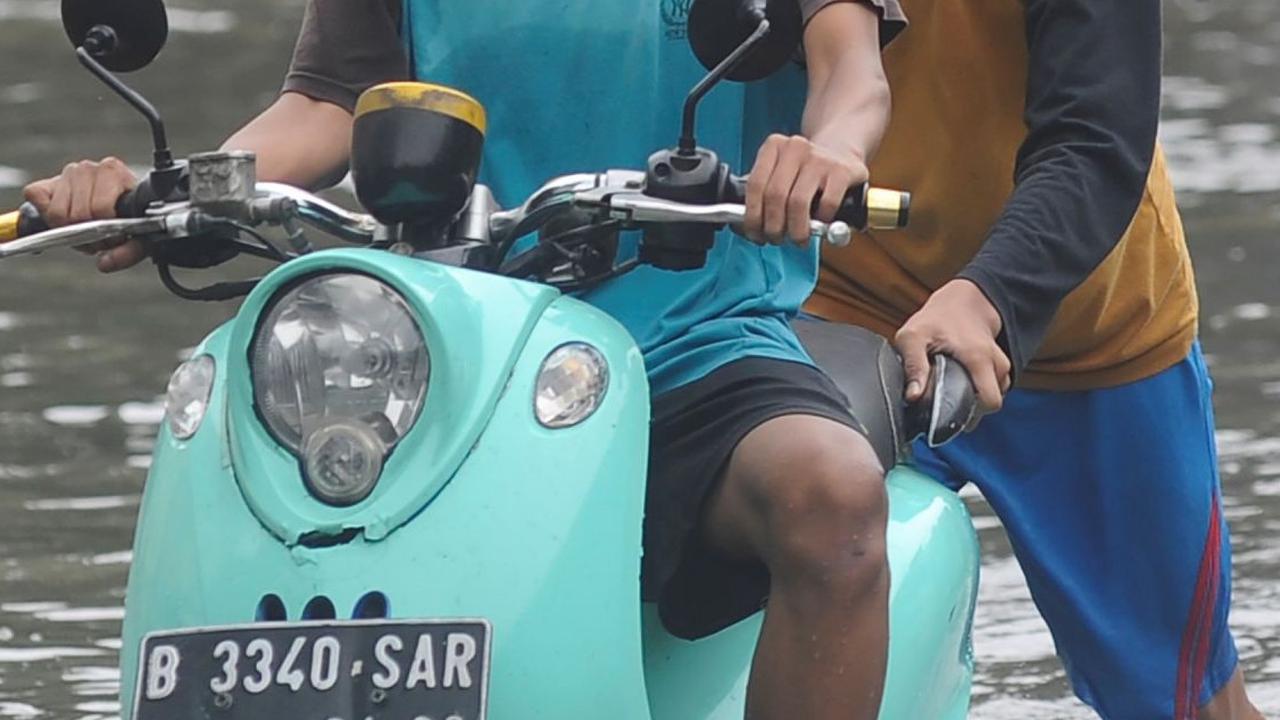 Akibat genangan yang cukup tinggi itu, sejumlah pengendara terpaksa mendorong kendaraannya. Foto: merdeka.com / Arie Basuki