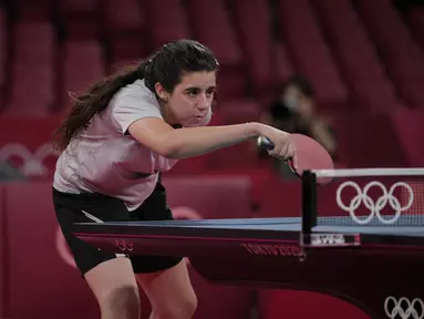 Petenis meja Suriah Hend Zaza mengembalikan pukulan Liu Jia dari Austria selama pertandingan babak penyisihan tunggal tenis meja putri di Olimpiade 2020 di Tokyo, Sabtu (24/7/2021). Hend Zaza, yang baru berusia 12 tahun, menjadi atlet termuda yang tampil di Olimpade Tokyo 2020. (AP Photo/Kin Cheung)