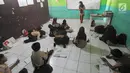 Sejumlah siswa belajar di lantai kelas di Madrasah Ibtidaiyah (MI) Misbahul Athfal, Kampung Cileuleuy, Desa Cibentang, Kecamatan Ciseeng, Bogor, Kamis (8/8/2019). Sekolah tersebut dibangun murni swadaya masyarakat  dengan jumlah siswa sebanyak 126 orang. (merdeka.com/Arie Basuki)