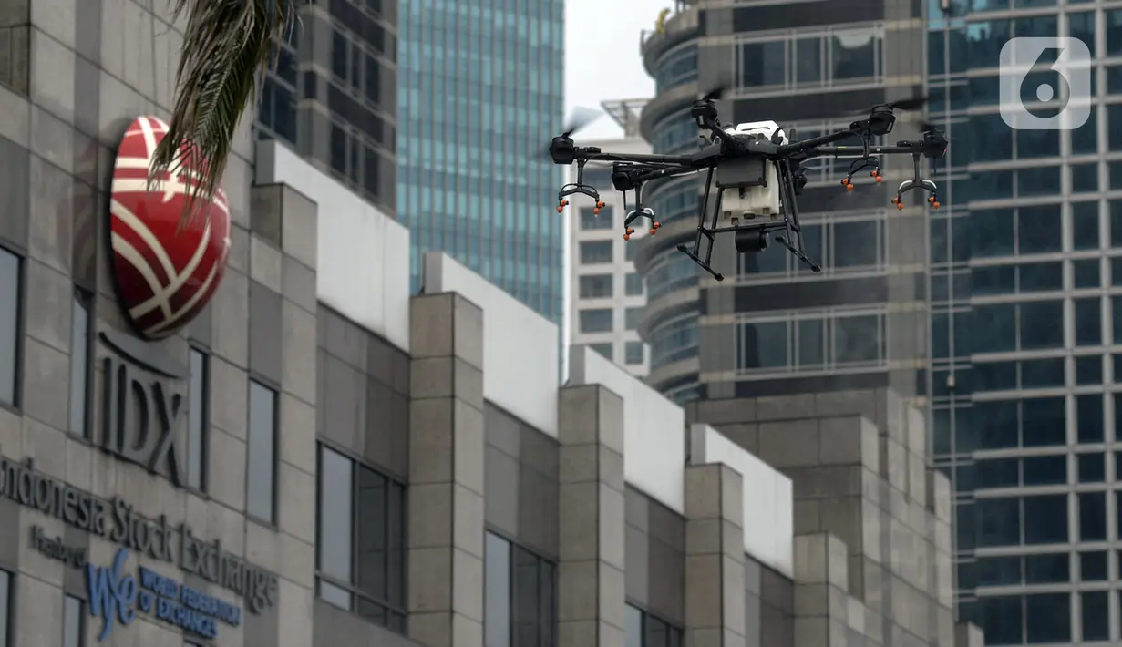 Drone menyemprotkan cairan disinfektan di Jalan Bursa Efek menuju Patung  Pemuda, Jakarta, Jumat (27/3/2020). Penyemprotan dilakukan untuk mencegah penyebaran virus corona COVID-19. (merdeka.com/Imam Buhori)