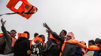 Pengungsi dan migran menerima pelampung saat diselamatkan oleh LSM Spanyol Proactiva Open Arms di atas sebuah kapal karet, 60 mil sebelah utara Al -Khum, Libya (18/2). Para pengungsi dan migran ini meninggalkan Libya untuk ke Eropa. (AP Photo/Olmo Calvo)