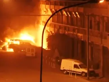 Tampak kendaraan terbakar didepan hotel Splendid, Ouagadougou, Burkina Faso, Jumat (15/1). Peristiwa terjadi setelah adu tembak antara pihak keamanan dan pasukan bersenjata yang diduga kelompok agama radikal. (REUTERS / Reuters TV)