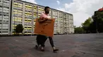 Percibald Garcia, pembaca cerita untuk anak-anak, menarik pengeras suara saat akan mendongeng di antara gedung-gedung di Mexico City pada 18 Juli 2020. Di tengah lockdown, Garcia hampir setiap hari mendatangi kompleks perumahan Tlatelolco untuk bercerita menghibur anak-anak. (AP/Marco Ugarte)