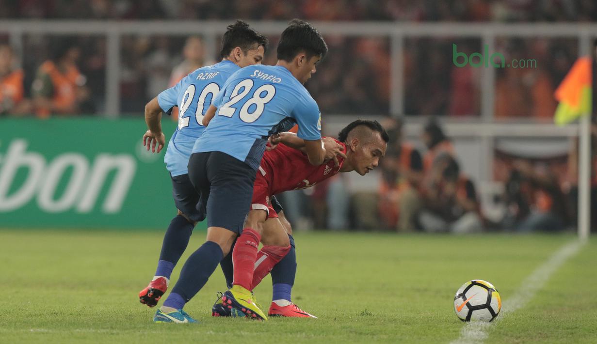 Gaya pemain Persija Jakarta, Riko Simanjuntak (tengah mengecoh dua pemain JDT pada laga Piala AFC 2018 di Stadion Utama Gelora Bung Karno, Jakarta, Selasa (10/4/2018). Persija Jakarta menang 4-0.  (Bola.com/Nick Hanoatubun)