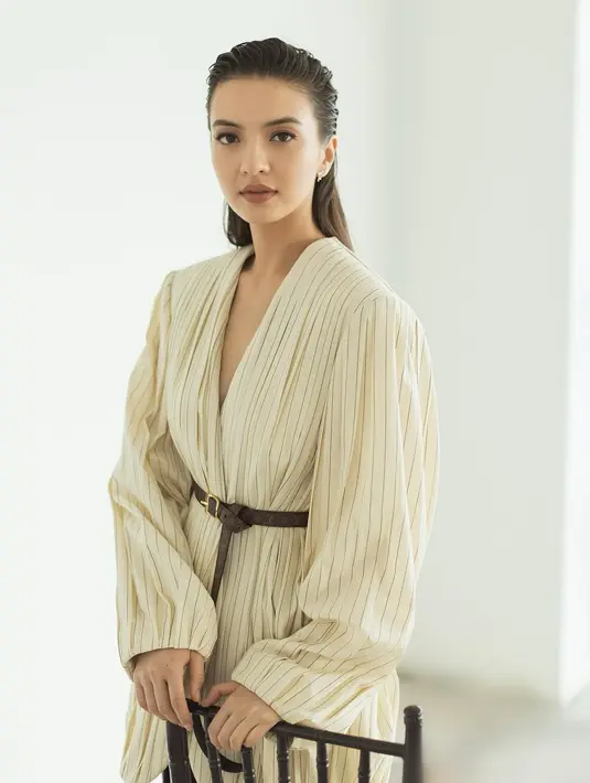 Raline Shah bergaya lady boss dengan busana bersiluet oversized. Sebuah atasan dengan garis leher yang dalam berwarna cokelat muda dengan corak garis, dipadukan mengenakan belt kecil untuk menambah aksen pada keseluruhan penampilan Raline. [Foto: Instagram/ralineshah]