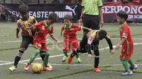 Pemain CISS (merah) berebut bola dengan pemain ATKL Tigers dalam laga U-8 Serpong City International Soccer Tournament di Sabnani Park, Tangerang Selatan. Sabtu (3/12/2016). (Bola.com/Arief Bagus)