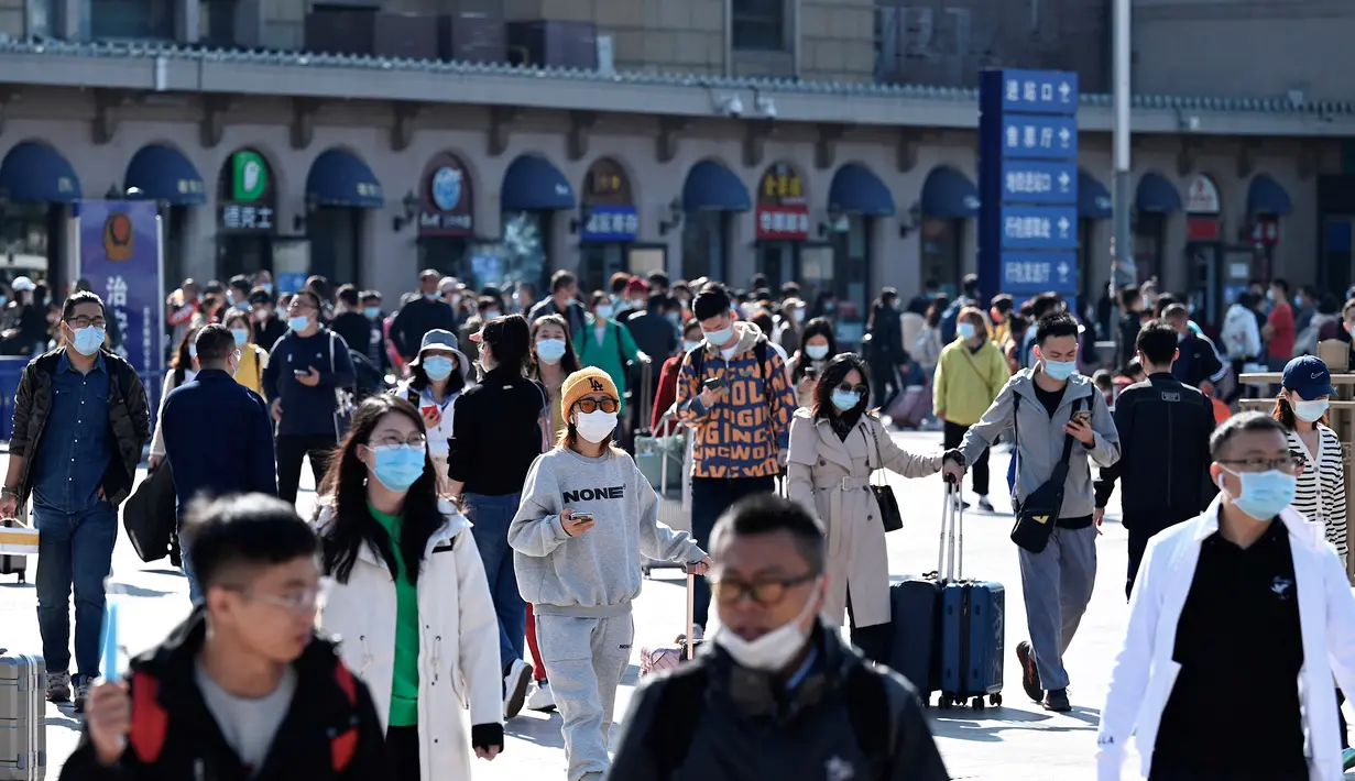 Orang-orang tiba di stasiun kereta api Beijing pada hari terakhir libur nasional "golden week" pada Kamis (7/10/2021). Liburan yang kerap disebut sebagai The Golden Week Holiday ini adalah peringatan berdirinya Republik Rakyat China pada tahun 1949. (JADE GAO / AFP)