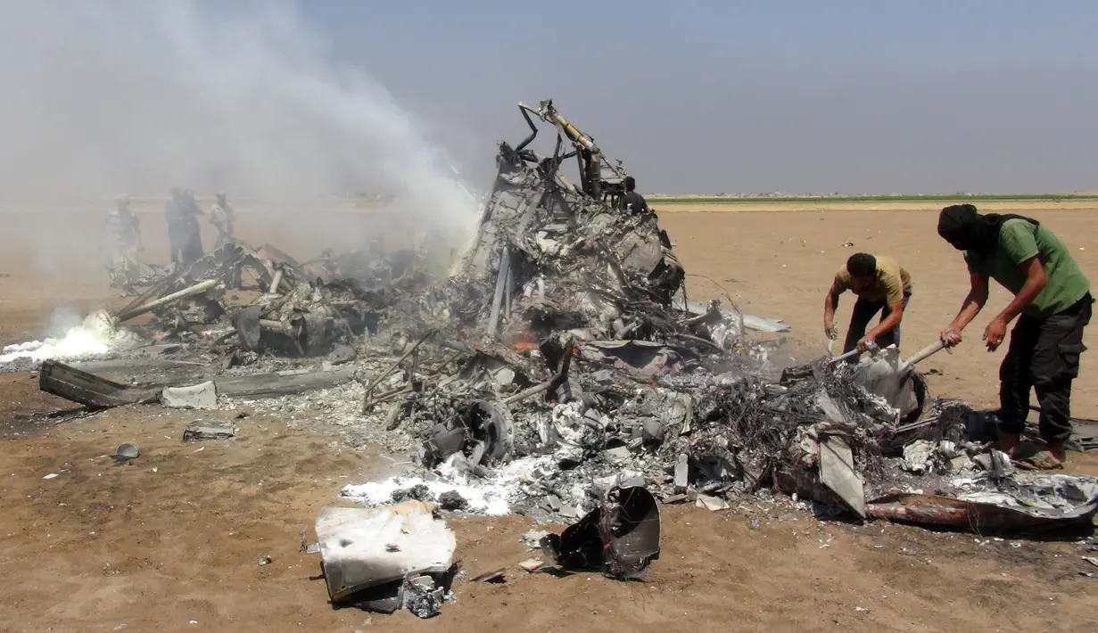 Puing-puing helikopter milik Rusia yang ditembak jatuh terlihat di wilayah Idlib, Suriah, Senin (1/8). Menurut laporan, helikopter berjenis Mi-8 itu dalam perjalanan kembali setelah membawa bantuan kemanusiaan ke Aleppo. (Mohamed al - Bakour/AFP)